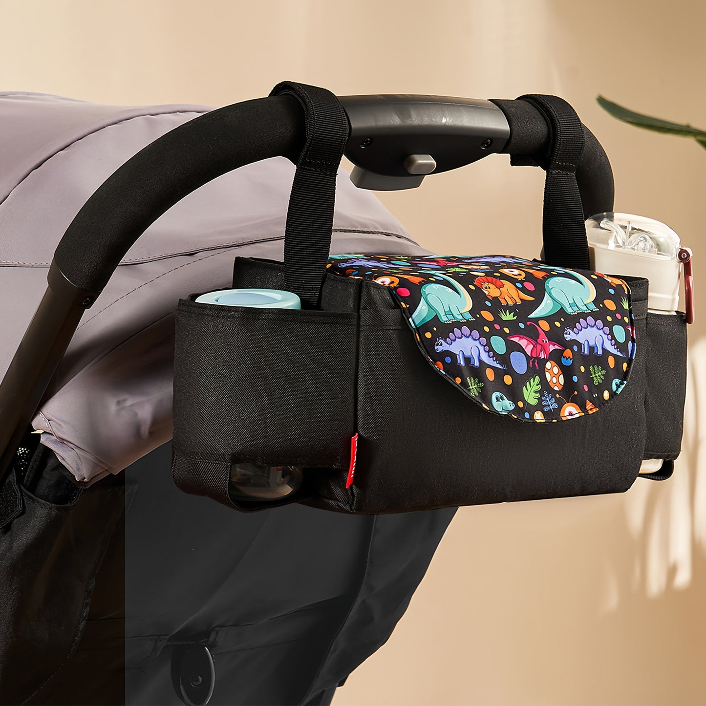 PACKD stroller organizer with insulated cup holders and dinosaur print flap